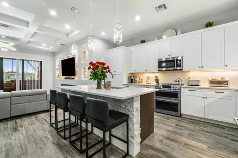 a kitchen with kitchen island granite countertop lots of counter top space and stainless steel appliances