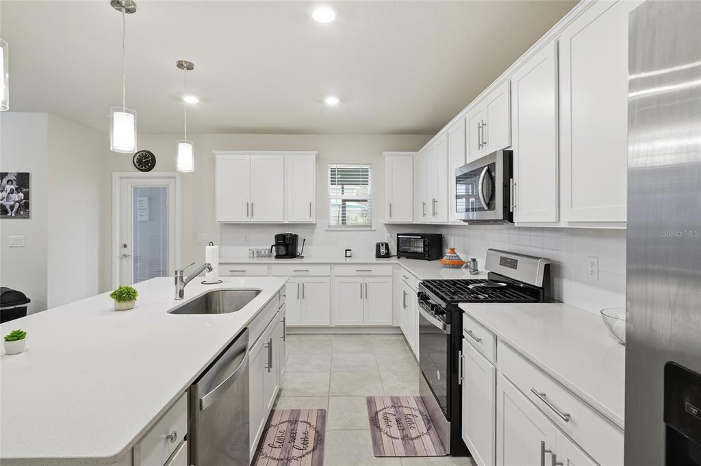 4071 Feather Tree Drive Apopka, FL 32712 - Photo 12 of 52 a kitchen with a sink a stove cabinets and a counter top space