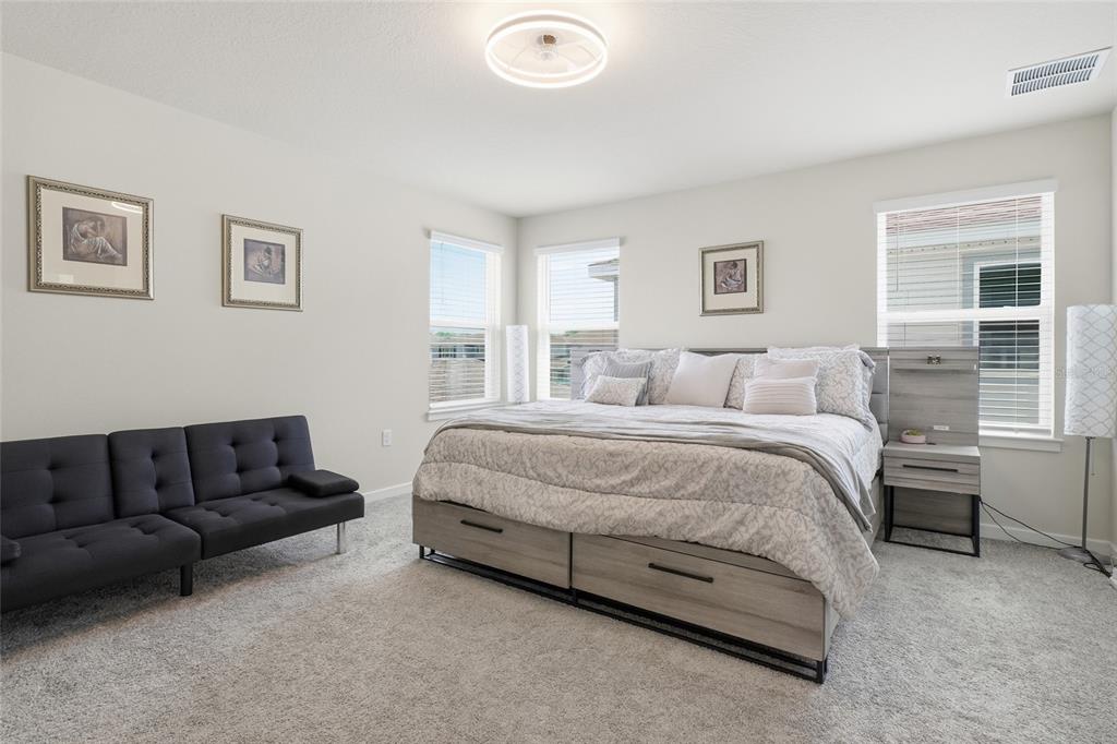 4071 Feather Tree Drive Apopka, FL 32712 - Photo 25 of 52 a spacious bedroom with a bed couch and window