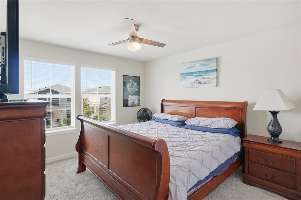 4071 Feather Tree Drive Apopka, FL 32712 - Photo 32 of 52 a bedroom with a large bed and a chandelier