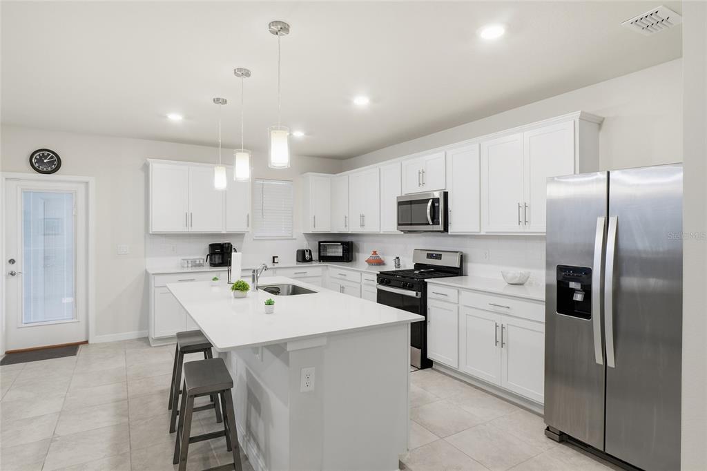 4071 Feather Tree Drive Apopka, FL 32712 - Photo 7 of 52 a kitchen with a refrigerator a sink cabinets and wooden floor