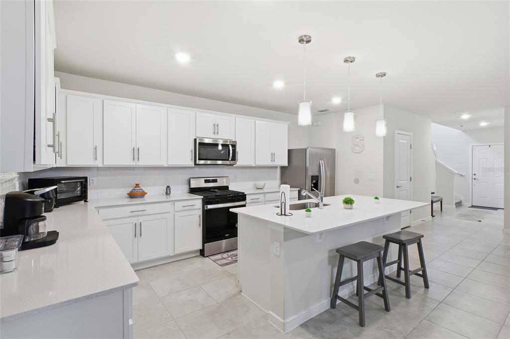 4071 Feather Tree Drive Apopka, FL 32712 - Photo 10 of 52 a kitchen with a sink a stove a refrigerator and white cabinets