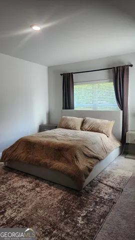 a bedroom with a bed and a large window