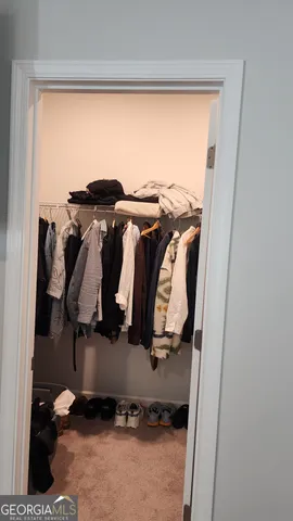 a view of walk in closet with clothes and shoes