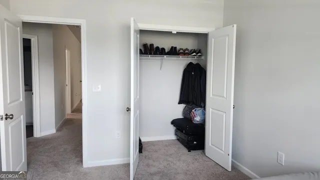 a view of walk in closet with clothes and shoes
