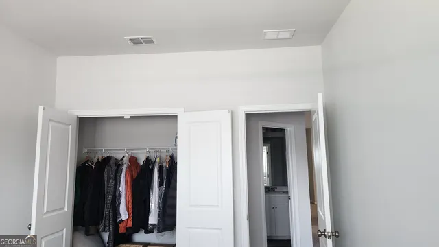 a view of walk in closet with clothes