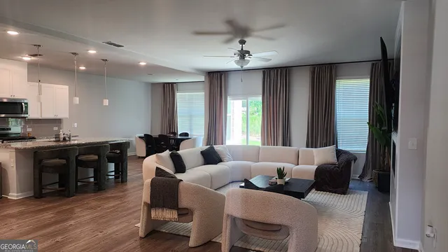 a living room with furniture and a wooden floor