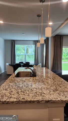 a large kitchen with a stove a refrigerator and wooden floor