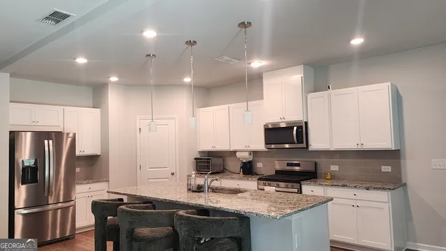 a kitchen with a sink a counter space appliances and cabinets