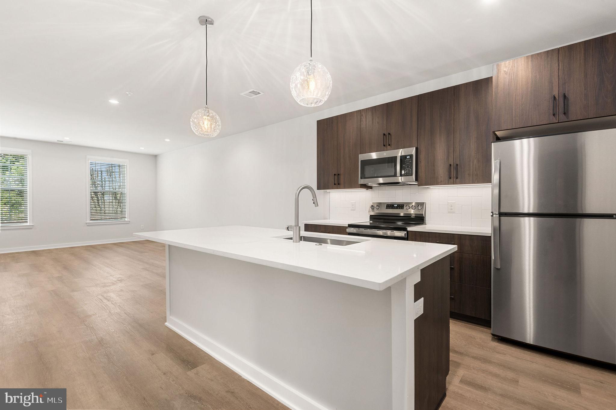 a kitchen with kitchen island a sink stainless steel appliances and cabinets