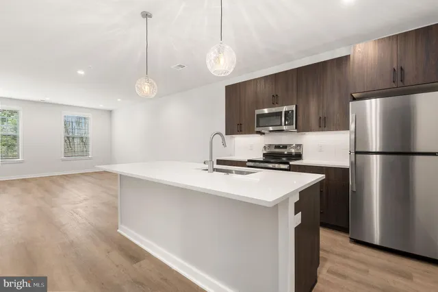 a kitchen with kitchen island a sink stainless steel appliances and cabinets