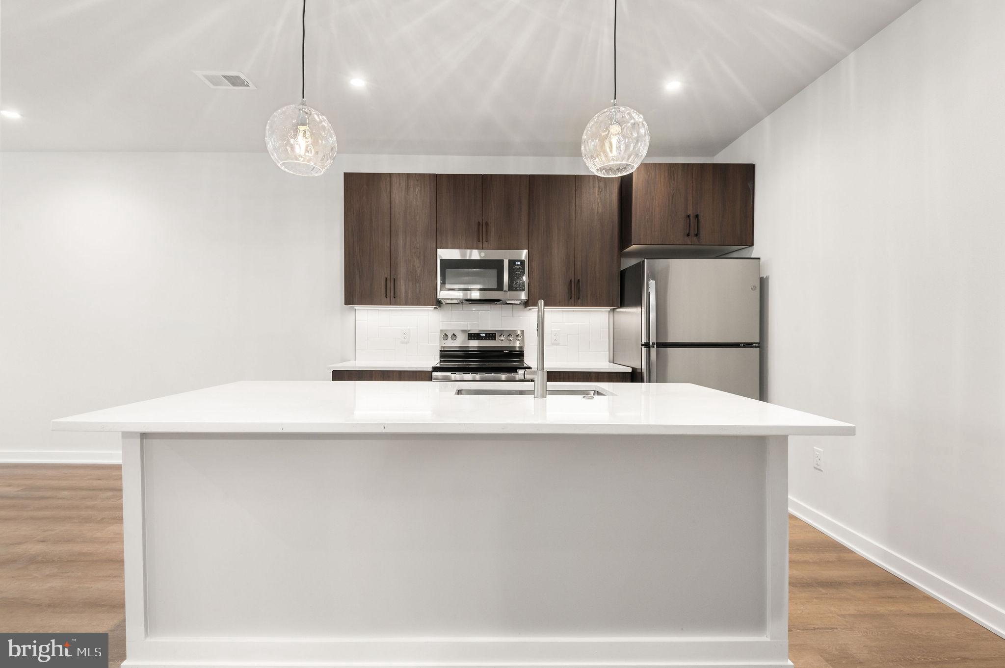 26 South York Road, Unit 204 Hatboro, PA 19040 - Photo 8 of 48 a kitchen with kitchen island stainless steel appliances a sink and a refrigerator
