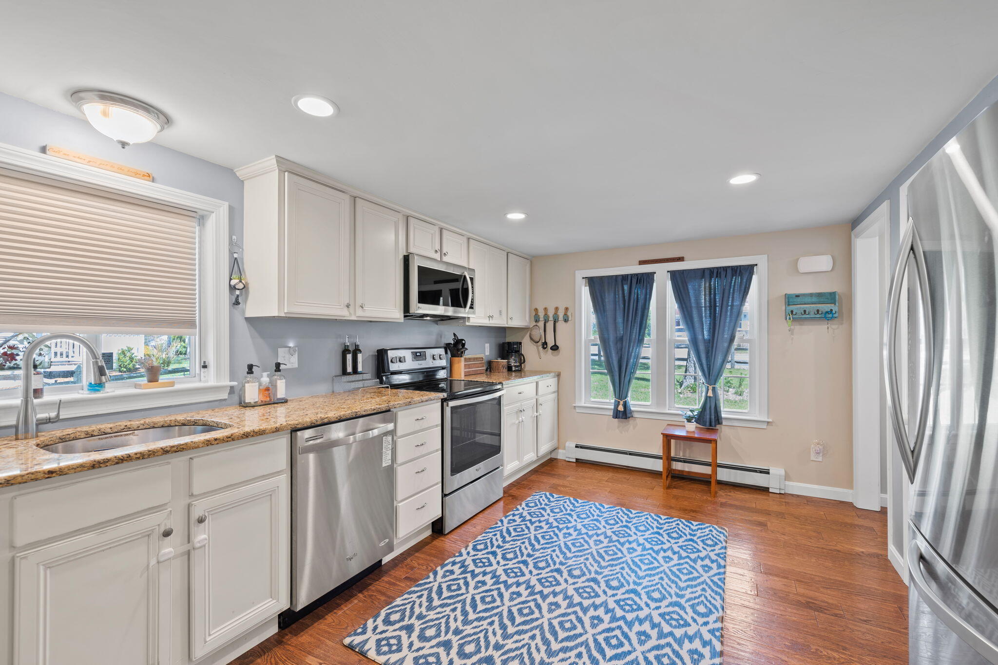 120 Puritan Road Buzzards Bay, MA 02532 - Photo 6 of 28 a kitchen with white cabinets a sink a window and stainless steel appliances