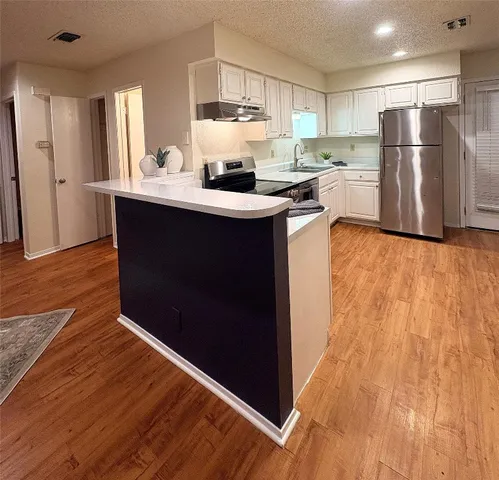 a kitchen with stainless steel appliances a refrigerator sink and cabinets