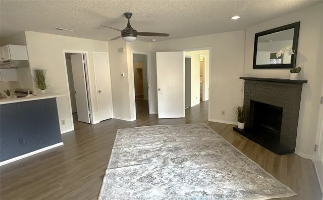 a view of a livingroom with wooden floor and a fireplace