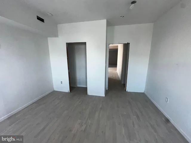 an empty room with closet and mirror