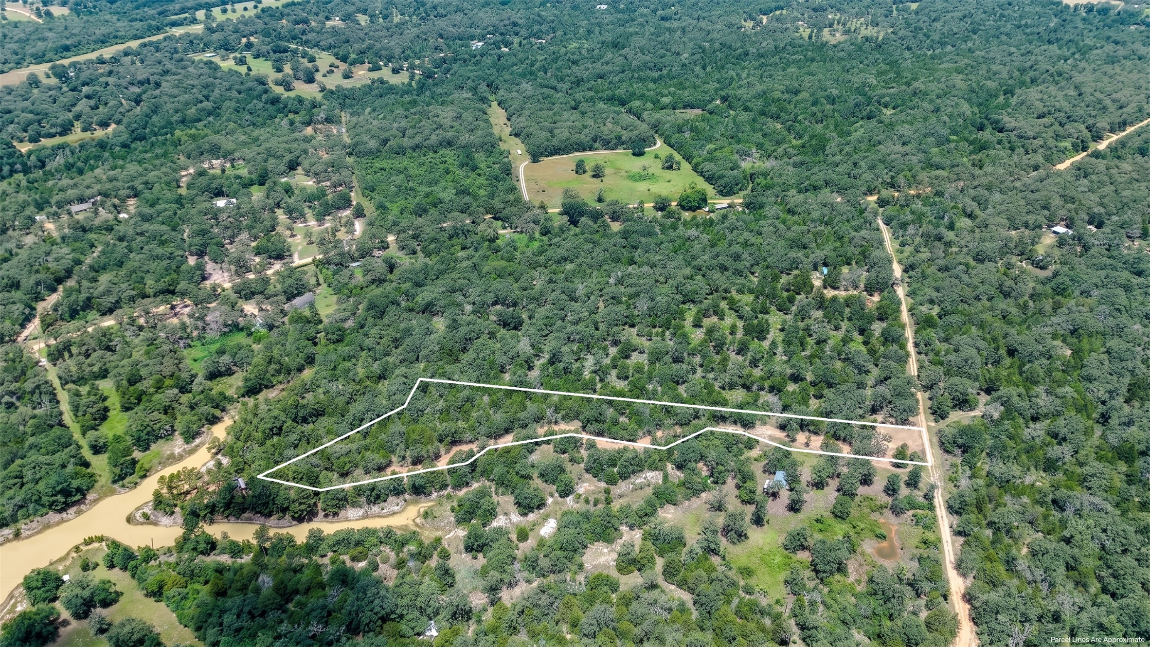 3428 (2.528 Acres In Lin Luce Ranches Milano, TX 76556 - Photo 15 of 23 A sweeping aerial perspective reveals a vast, tree-lined lot bordered by a winding river.