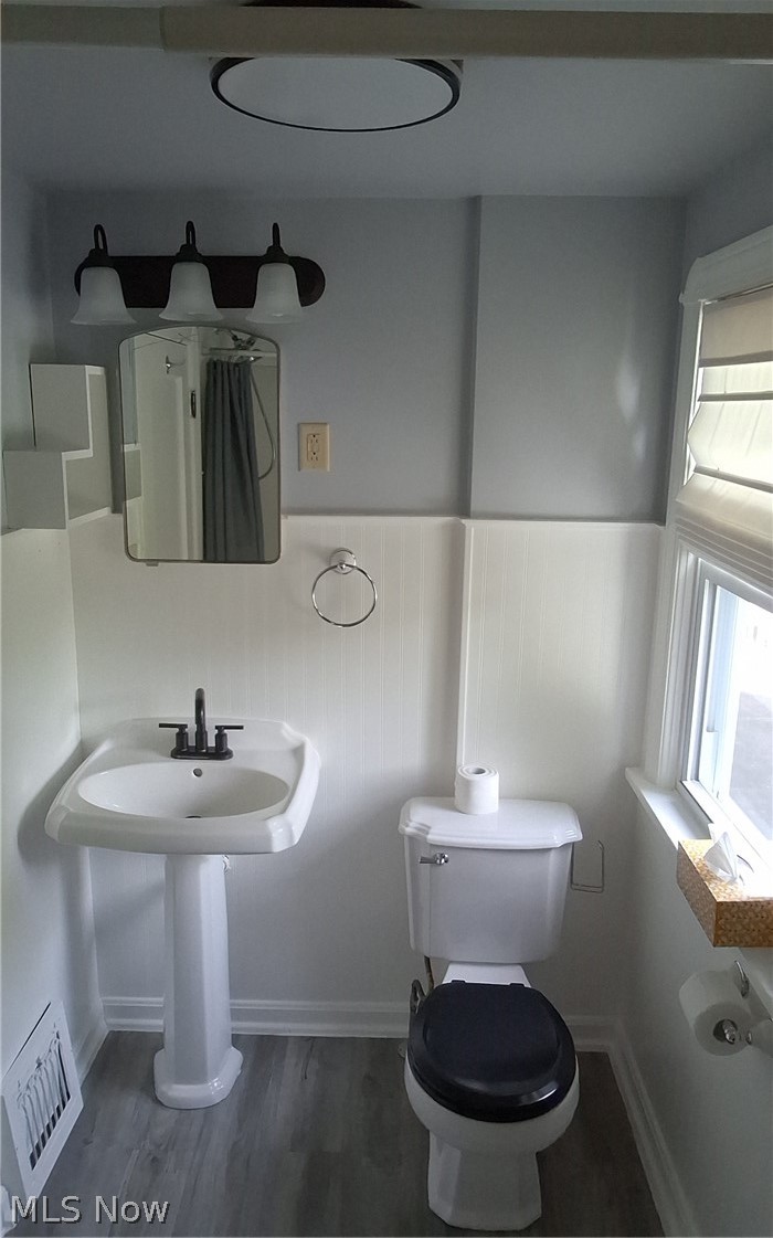 236 Bowland Road Mansfield, OH 44907 - Photo 25 of 34 Bathroom featuring a pedestal sink with a matte black faucet, wainscoting, and wood-finish flooring