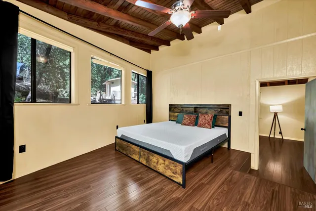 a spacious bedroom with a bed and wooden floor