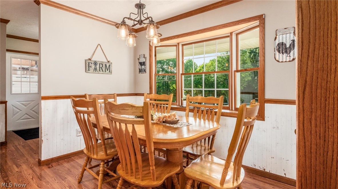 9393 Pioneer Road Byesville, OH 43723 - Photo 12 of 35 Dining area featuring an inviting chandelier, crown molding, and wood-type flooring