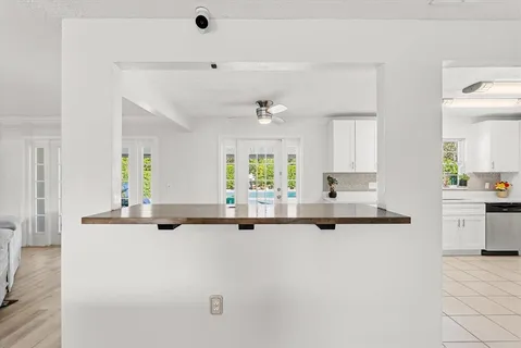 a kitchen with kitchen island sink stove and white cabinets