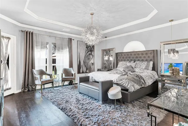a bedroom with a bed a couches and a chandelier
