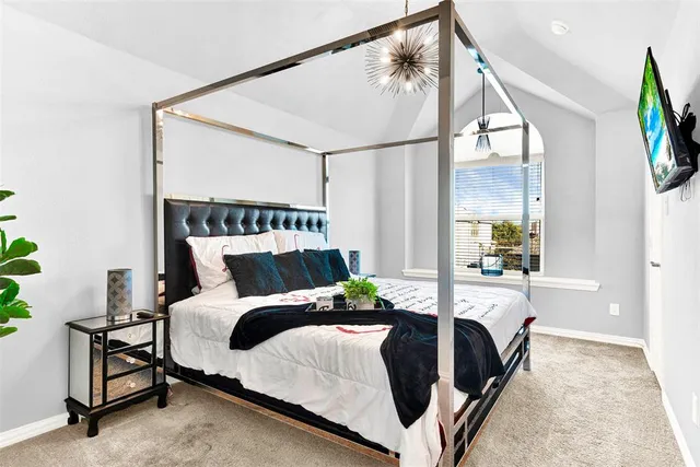 a bedroom with a large bed and a chandelier