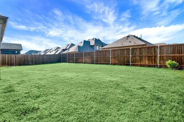 a view of a small yard in front of a house with large trees