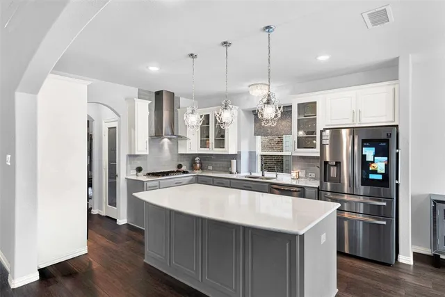 a kitchen with stainless steel appliances granite countertop a sink a stove and a refrigerator