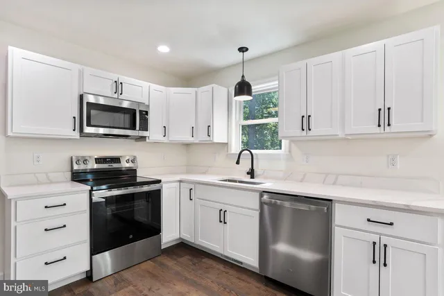 a kitchen with white cabinets and white appliances