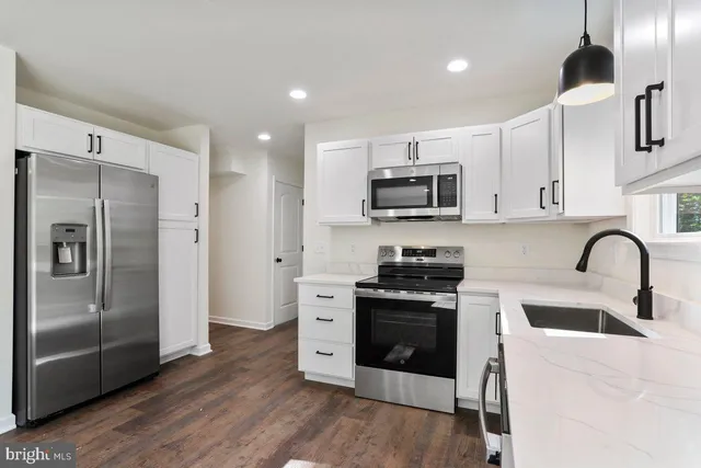 a kitchen with stainless steel appliances granite countertop a stove a refrigerator and a sink