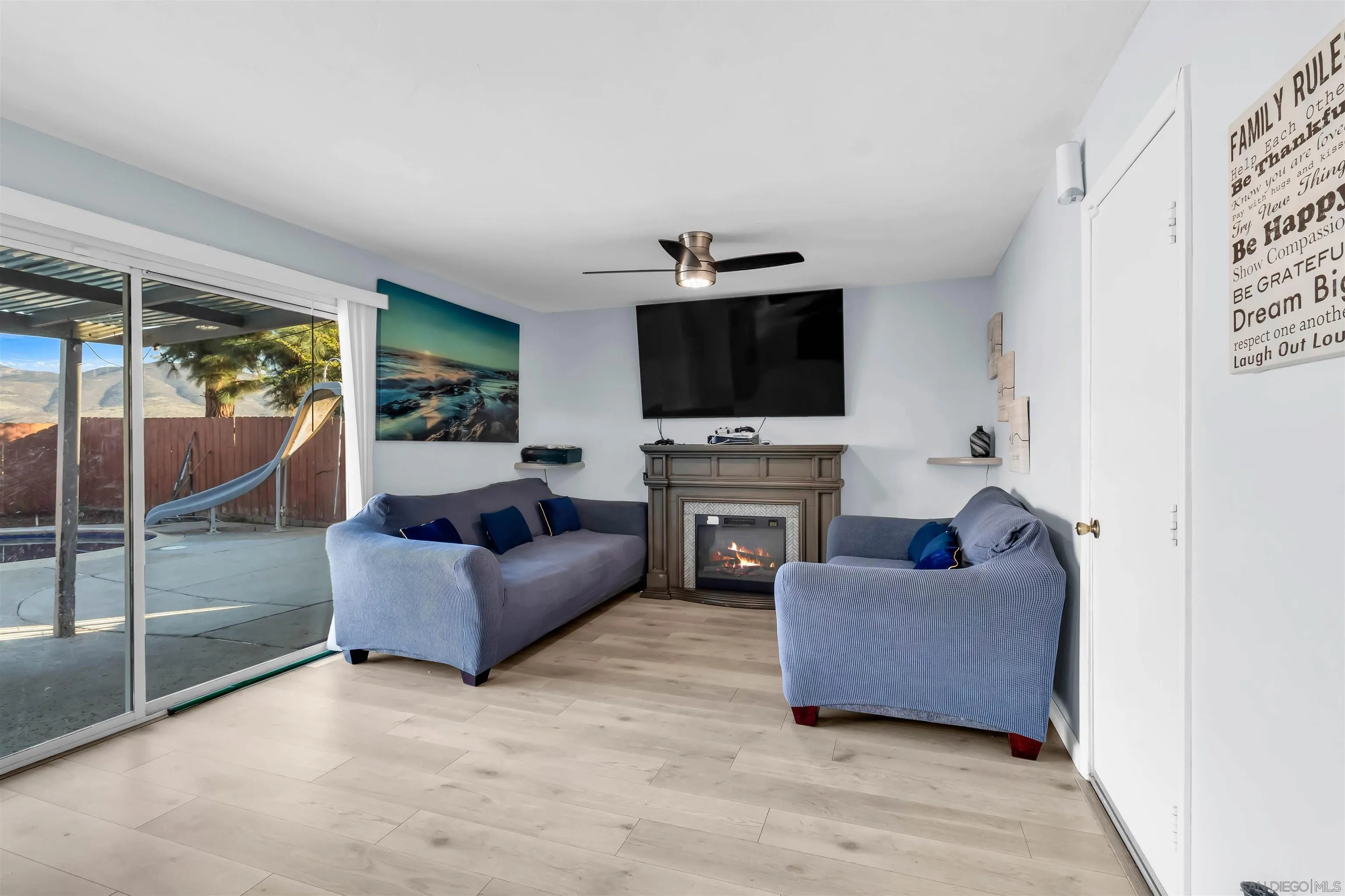 341 Paraiso Avenue Spring Valley, CA 91977 - Photo 13 of 35 a living room with furniture a flat screen tv and a fireplace