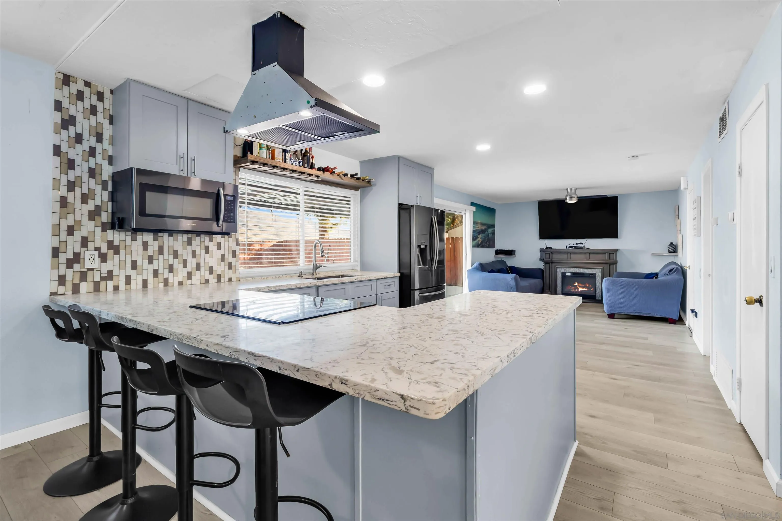 341 Paraiso Avenue Spring Valley, CA 91977 - Photo 9 of 35 a kitchen with stainless steel appliances granite countertop a stove top oven a sink dishwasher a dining table and chairs with wooden floor