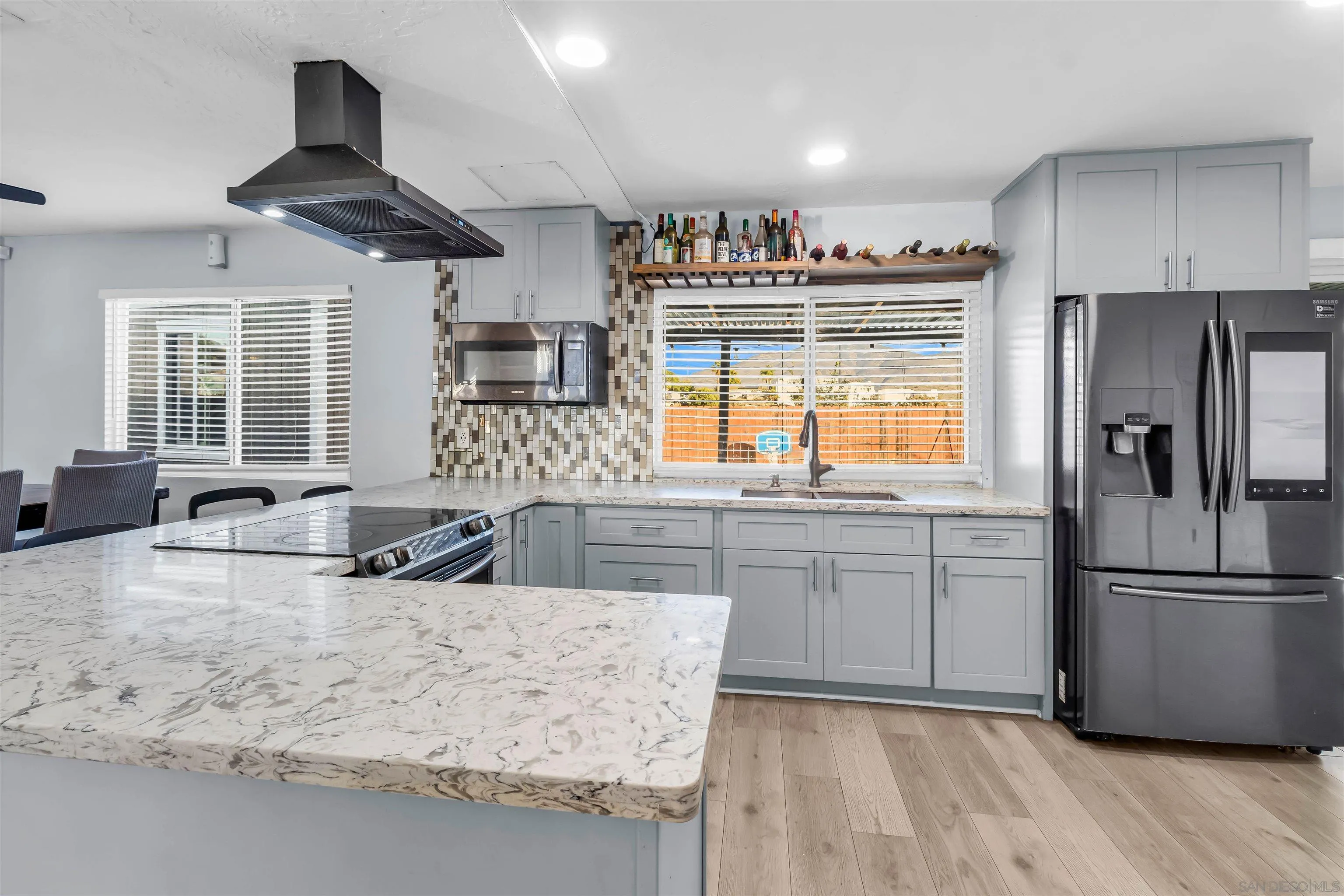 341 Paraiso Avenue Spring Valley, CA 91977 - Photo 10 of 35 a kitchen with stainless steel appliances granite countertop a refrigerator a stove a sink a oven and a refrigerator with wooden floor