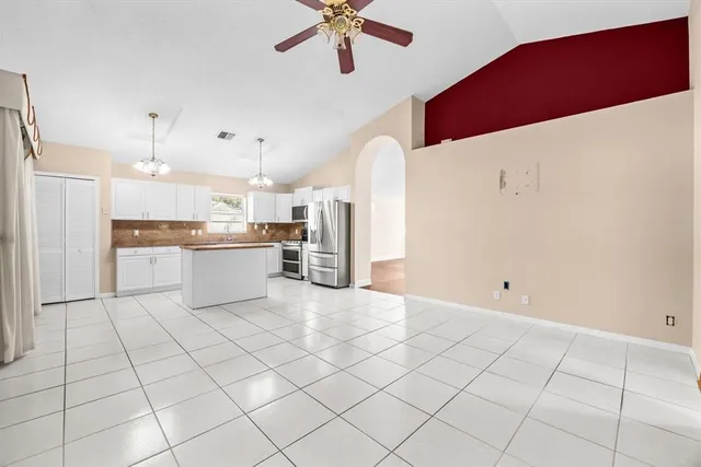 a kitchen with stainless steel appliances kitchen island granite countertop a refrigerator and a stove top oven
