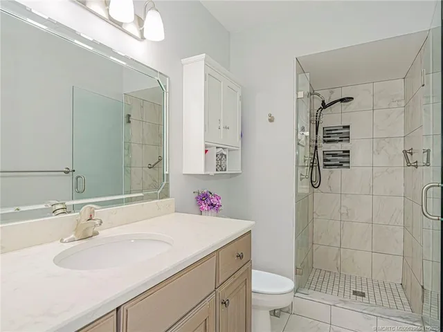 a bathroom with a sink toilet vanity and shower