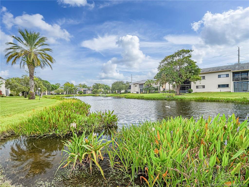 3001 Southeast Aster Lane, Unit 908 Stuart, FL 34994 - Photo 26 of 35 a view of a lake with a building in the background