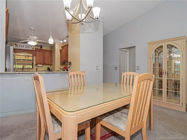 a dining room with furniture a chandelier and wooden floor