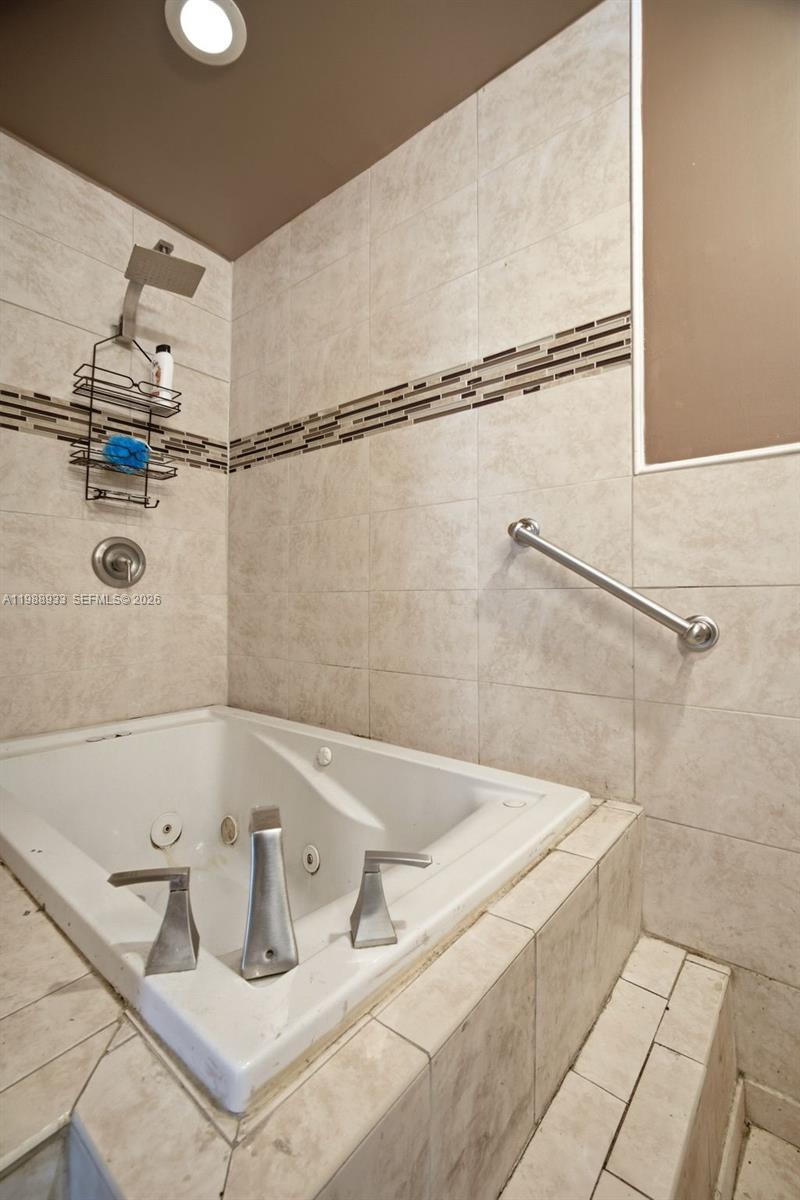841 Southwest 55th Avenue Margate, FL 33068 - Photo 21 of 26 a bath tub sitting next to a white sink and a shower