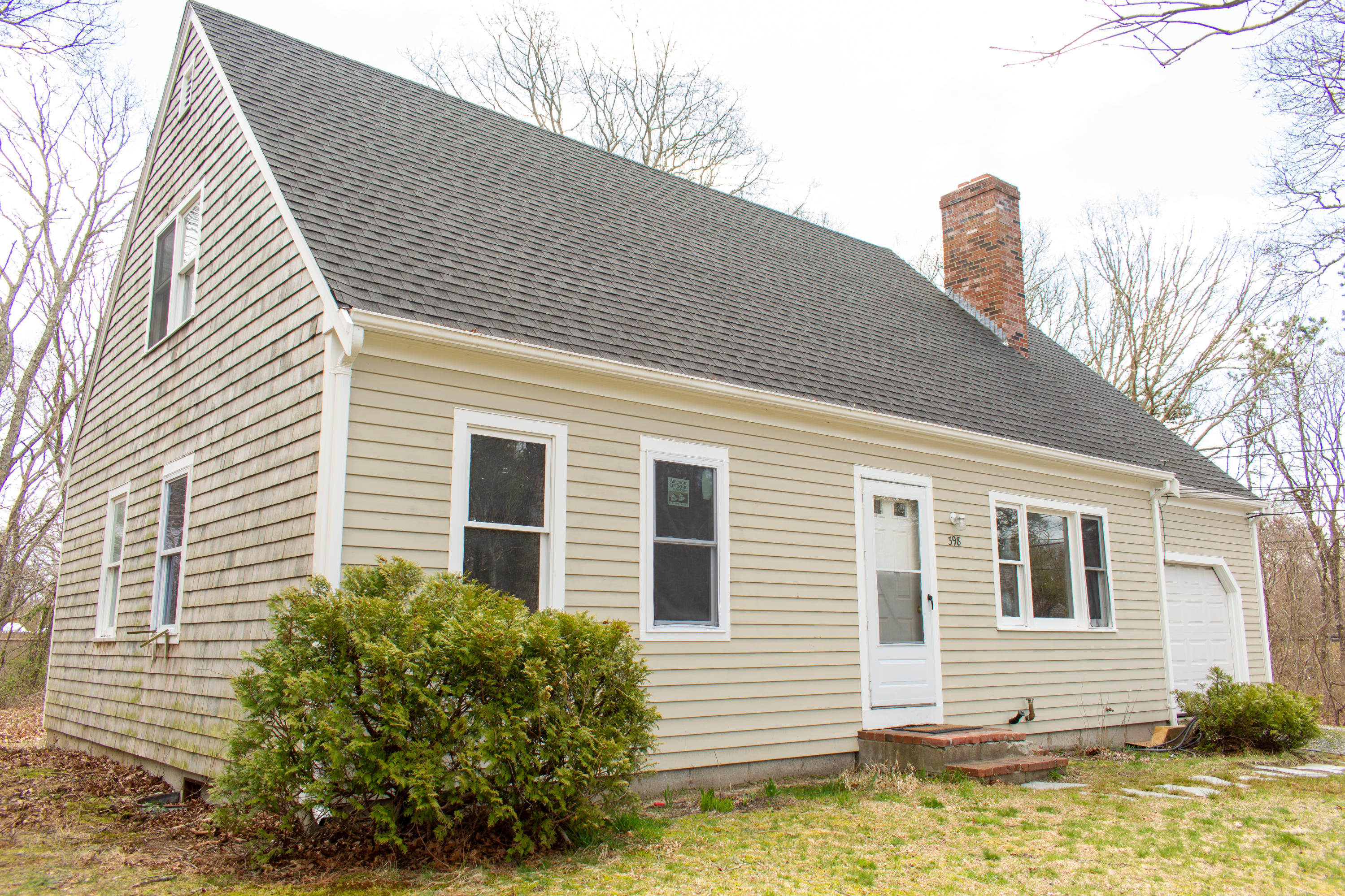 398 Lincoln Rd Extension Hyannis, MA 02601 - Photo 1 of 26 a front view of a house with a yard and garage