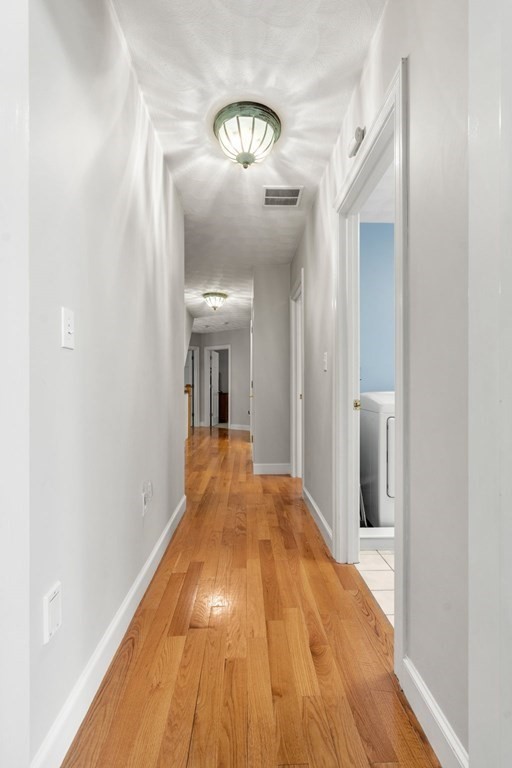 24 Whitney Road Boxford, MA 01921 - Photo 21 of 42 a view of a hallway with wooden floor and a chandelier