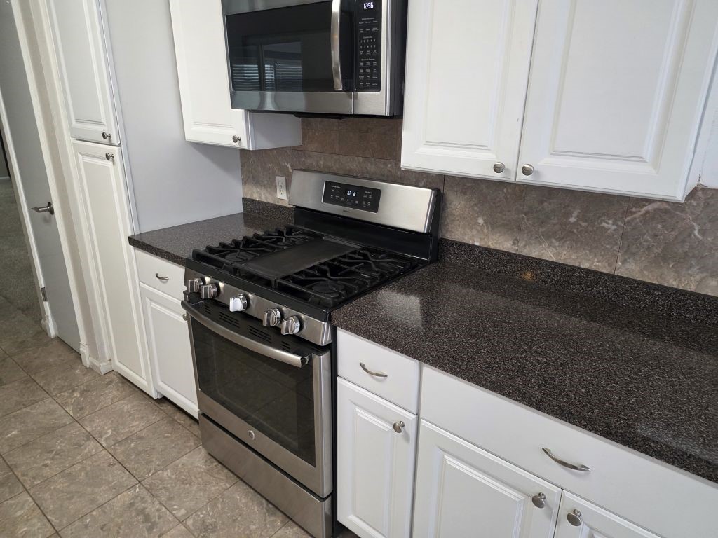 13600 Farm To Market Road 1314 Conroe, TX 77302 - Photo 9 of 26 a kitchen with granite countertop white cabinets and stainless steel appliances