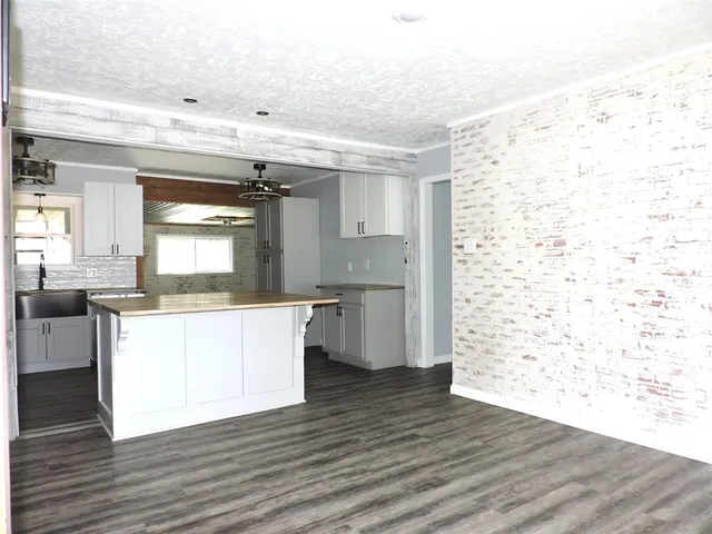 a kitchen with stainless steel appliances wooden floor and a refrigerator