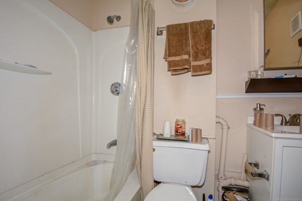 64 Beacon Street Chelsea, MA 02150 - Photo 5 of 10 a bathroom with a toilet sink and shower curtain