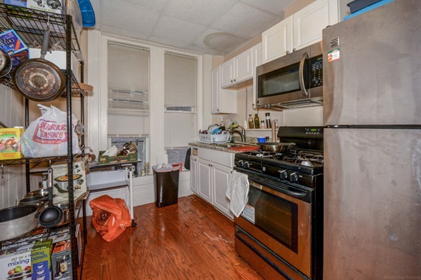 64 Beacon Street Chelsea, MA 02150 - Photo 10 of 10 a kitchen with stainless steel appliances granite countertop a stove top oven a sink and a microwave
