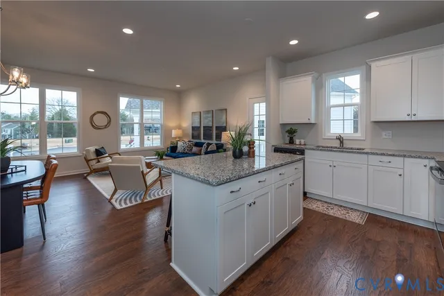 a open kitchen with center island white cabinets and stainless steel appliances