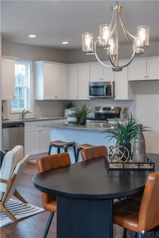 a view of a dining room with furniture a chandelier and wooden floor