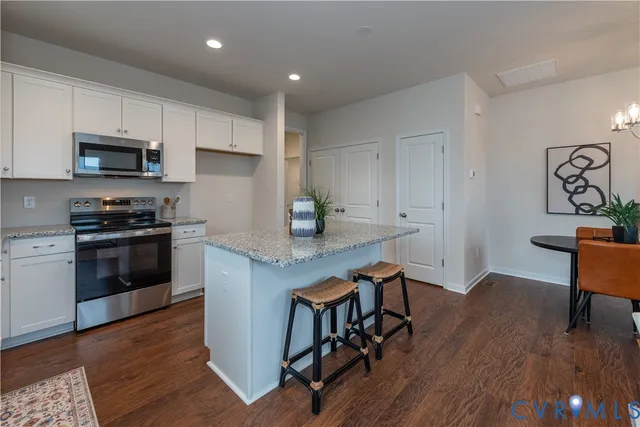 a kitchen with stainless steel appliances a stove a sink a microwave a refrigerator and cabinets