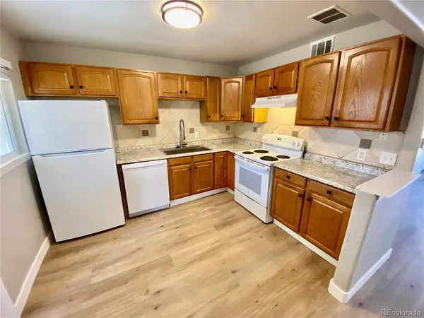 a kitchen with stainless steel appliances granite countertop a sink stove refrigerator and cabinets