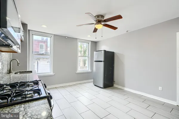 a kitchen with stainless steel appliances granite countertop a refrigerator and a stove top oven